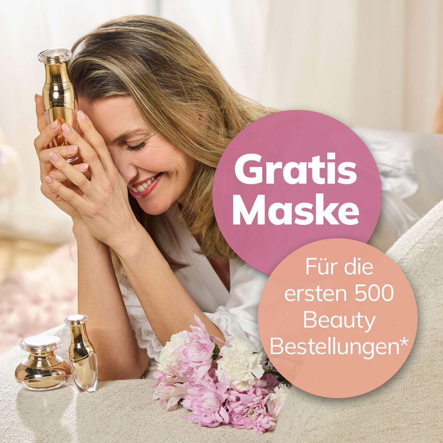 Gratis Maske – für die ersten 500 Beauty Bestellungen* Frau mit langen Haaren hält goldfarbenes Kosmetikfläschchen vor ihr Gesicht, auf Tisch liegen weitere Fläschchen und rosa-weiße Blumen, daneben zwei Kreise mit Text 'Gratis Maske' und 'Für die ersten 500 Beauty Bestellungen*'